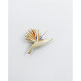 This botanical-inspired enamel pin is handmade and features an original illustration of the striking Bird of Paradise plant.