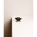 This sweet little enamel pin is handmade and features one of our cutest little pollinators!